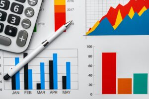 Business graphs paper and calculator on table