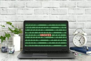 Laptop computer with a Hacked warning on the screen. Concept for hacker cyber attack danger