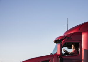 View of a Caucasian woman driver in the cab of her commercial truck.